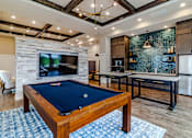 Thumbnail 8 of 41 - A pool table is in the middle of a room with a TV and a fireplace.