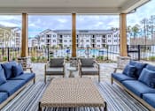 Thumbnail 1 of 41 - A patio with a pool and apartment buildings in the background.