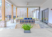 Thumbnail 13 of 41 - A patio with a blue couch and a plant in a pot.