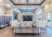 Thumbnail 4 of 41 - A modern living room with a stone fireplace and a large coffee table.
