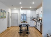Thumbnail 25 of 41 - A modern kitchen with a table set for two.