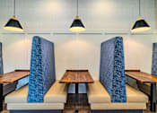 Thumbnail 7 of 41 - A restaurant with blue chairs and tables.