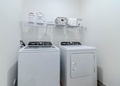 Thumbnail 34 of 41 - Two white front loading washing machines in a laundry room.