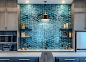 Thumbnail 12 of 41 - A kitchen with a blue brick wall and wooden cabinets.