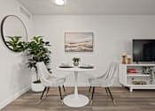 Thumbnail 7 of 23 - A white dining table with two chairs and a potted plant in a modern room.