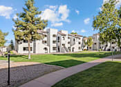 Thumbnail 22 of 23 - A white building with a green lawn in front.