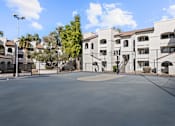 Thumbnail 18 of 23 - A large white building with a courtyard in front.