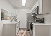 Thumbnail 3 of 23 - A kitchen with white cabinets and a black stove top oven.