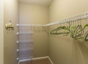 Thumbnail 5 of 15 - a walk in closet with shelves and a mirrored closet door
