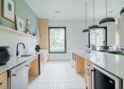 Thumbnail 41 of 43 - a kitchen with white tile floors and light wood cabinets