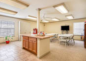 Thumbnail 16 of 23 - A kitchen with a table and chairs and a television.
