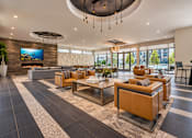 Thumbnail 23 of 30 - A modern living room with a large television and comfortable seating.