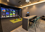Thumbnail 20 of 30 - A room with a bar and a screen showing different images.