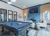 Thumbnail 13 of 39 - A pool table is in the middle of a room with a television and a couch.