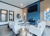 Thumbnail 12 of 39 - A modern living room with white furniture and a flat screen TV mounted on the wall.
