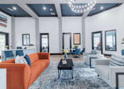 Thumbnail 5 of 39 - A modern living room with a large orange sofa and a black coffee table.