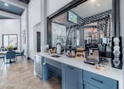 Thumbnail 10 of 39 - A kitchen with blue chairs and a counter with a coffee maker on it.