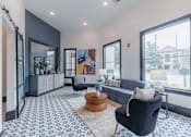 Thumbnail 7 of 39 - A living room with a black chair and a patterned floor.