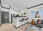 Thumbnail 15 of 29 - A modern kitchen with a bar area and a large painting of a horse on the wall.