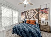 Thumbnail 20 of 29 - A bedroom with a large bed and a ceiling fan.
