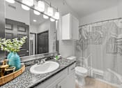 Thumbnail 22 of 29 - A bathroom with a white sink and a white toilet.