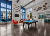 Thumbnail 10 of 29 - A pool table is in the middle of a room with a blue wall and a television.