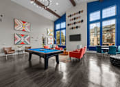Thumbnail 5 of 29 - A pool table is surrounded by chairs in a room with wood flooring.
