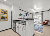 Thumbnail 16 of 29 - A kitchen with white cabinets and a black countertop.