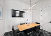 Thumbnail 24 of 33 - A modern dining room with a wooden table and black chairs.