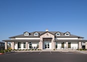 Thumbnail 14 of 21 - A large building with a parking lot in front.
