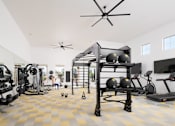Thumbnail 16 of 21 - A person is working out in a spacious gym with a variety of equipment.