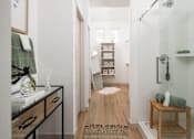 Thumbnail 7 of 21 - A bathroom with a white shower and a wooden stool.