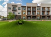 Thumbnail 31 of 36 - an open field of grass in front of an apartment building