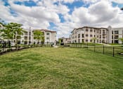 Thumbnail 30 of 33 - A large grassy area in front of apartment buildings.