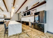 Thumbnail 18 of 33 - A kitchen with a marble table and wooden floors.