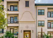 Thumbnail 33 of 33 - A large beige building with a cross on the front door.