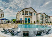 Thumbnail 26 of 33 - A large building with a pool in front of it.