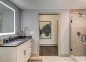 Thumbnail 8 of 33 - A bathroom with a walk-in shower and a large mirror.