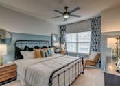 Thumbnail 10 of 33 - A bedroom with a large bed and a ceiling fan.
