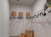 Thumbnail 9 of 33 - A room with a carpeted floor and a rack of hangers.