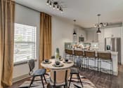 Thumbnail 4 of 33 - A modern kitchen with a dining table set for four.
