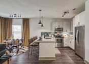 Thumbnail 3 of 33 - A modern kitchen with a dining table and chairs.