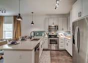 Thumbnail 6 of 33 - A modern kitchen with stainless steel appliances and white cabinets.