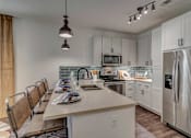 Thumbnail 5 of 33 - A modern kitchen with a long table and chairs.