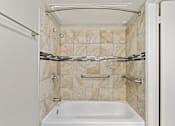 Thumbnail 10 of 16 - A white bathroom with a tub and a shower.
