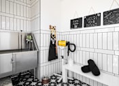 Thumbnail 15 of 19 - A bathroom with a white tiled wall and a black and white floor.