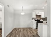 Thumbnail 4 of 20 - an empty kitchen with white appliances and a wood floor