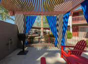 Thumbnail 19 of 20 - a patio with red chairs and blue and white curtains