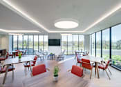 Thumbnail 18 of 28 - A modern dining room with red chairs and a wooden table.