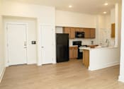 Thumbnail 8 of 28 - A kitchen with a black fridge and wooden cabinets.